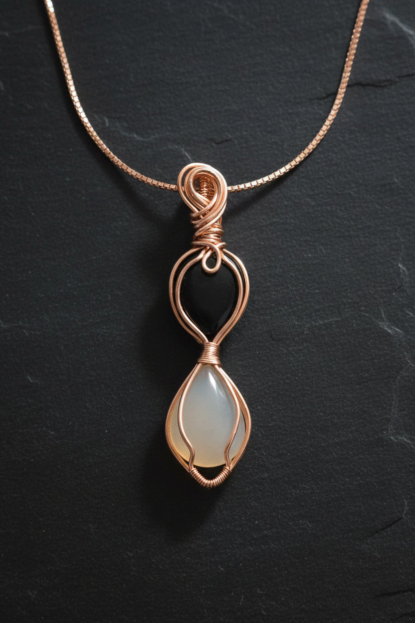 Black onyx and white chalcedony hourglass pendant in copper